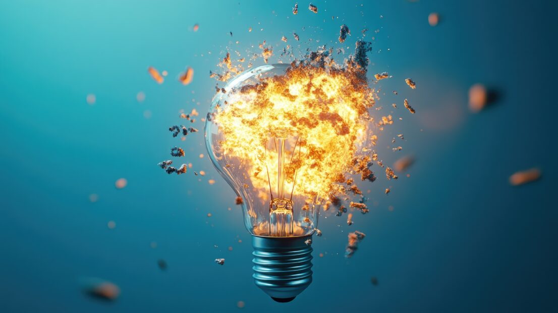 3D image of a light bulb breaking apart with fire, isolated on a blue background, showcasing intensity.